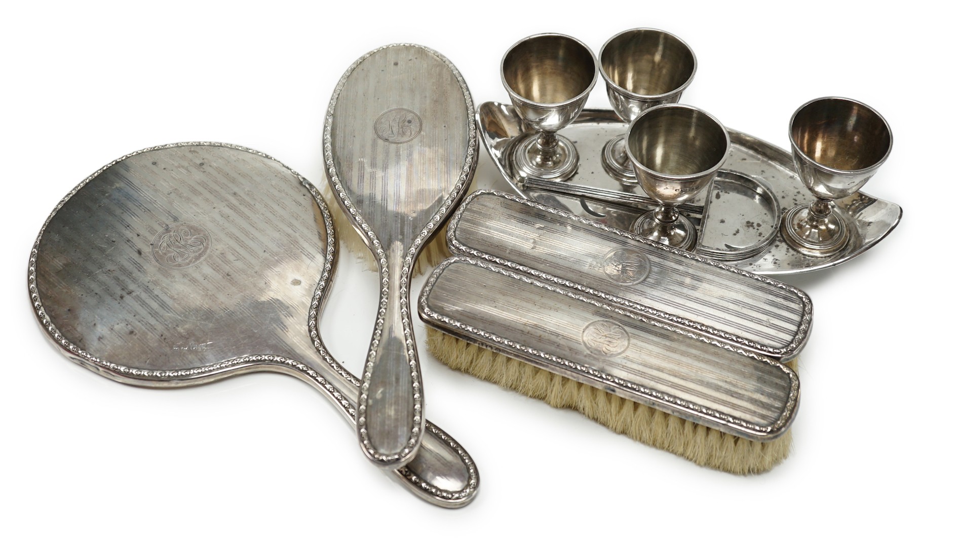 A late Victorian silver egg cruet, Martin, Hall & Co, Sheffield, 1889 (a.f. and lacking spoons), 12.3oz, and a later four piece silver mounted mirror and brush set.